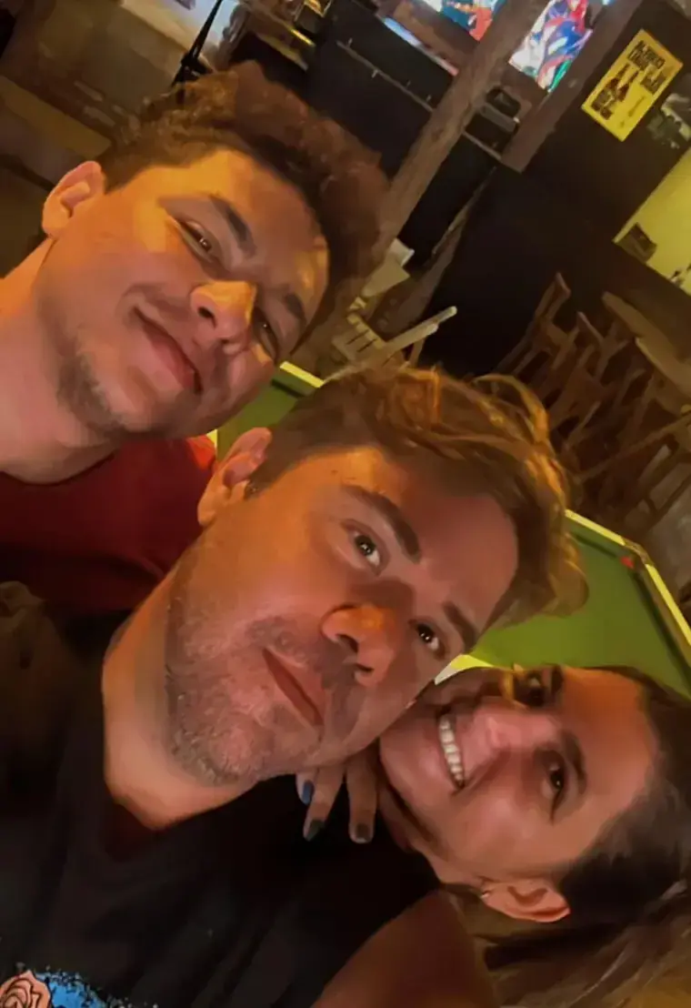 Três amigos numa selfie perto da mesa de sinuca